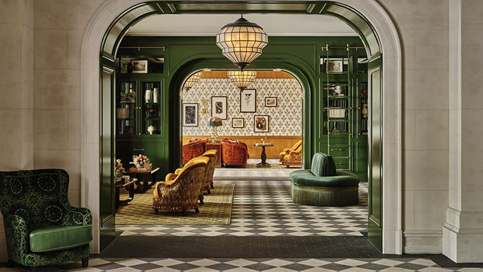 The lobby of the Four Seasons Hotel Boston featuring ornate furniture and tile flooring with walls either painted green or featuring patterned wallpaper.