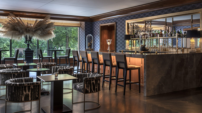 One of the bars at the Four Seasons Hotel Boston, featuring chic decor and a striking blue wallpaper.