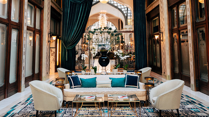 The Four Seasons Hotel Gresham Palace Budapest's incredible lobby, featuring velvet curtains and a stunning chandelier.