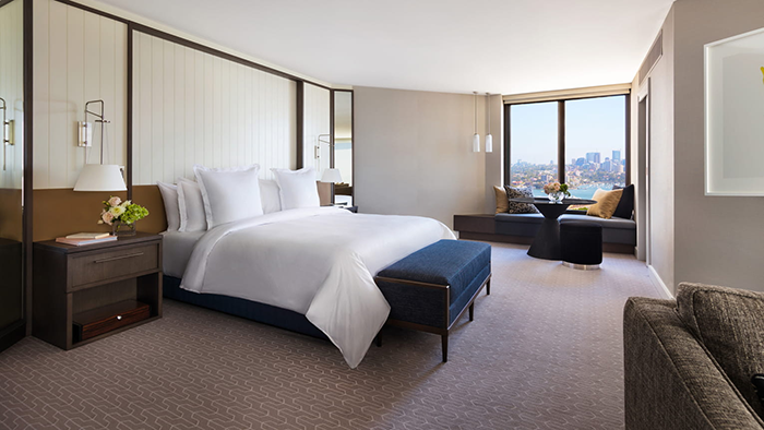A guest room in the Four Seasons Hotel Sydney. The room is quite spacious, with a nice view outside the window.