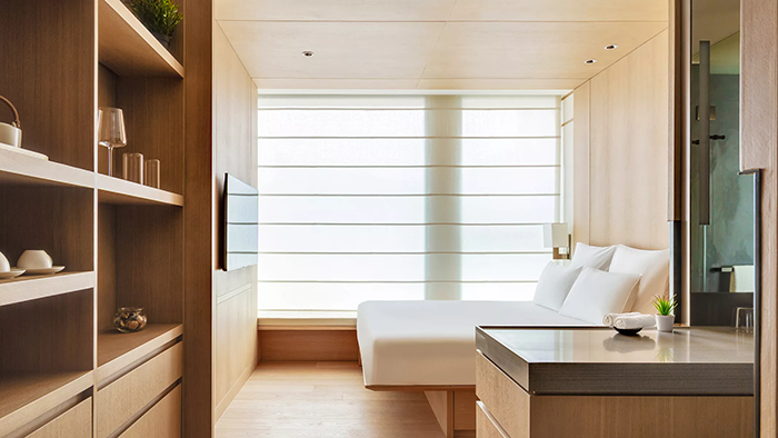 A guest room at the AKI Hong Kong - MGallery hotel. The space sports an earthy, minimalist aesthetic.