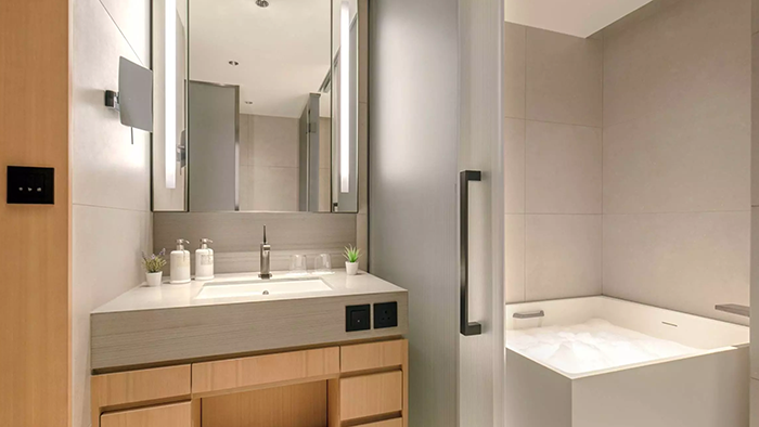 A guest bathroom at the AKI Hong Kong - MGallery hotel. The space sports an clean, minimalist aesthetic.