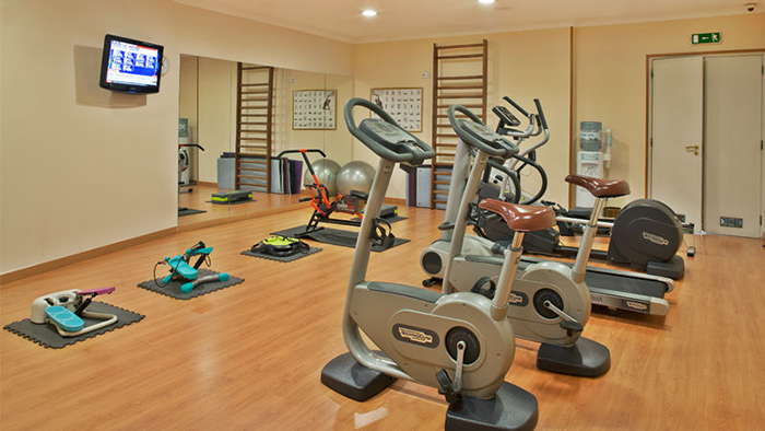 The Avenida Palace hotel fitness center. A variety of exercise equipment waits to be utilized by the hotel guests.