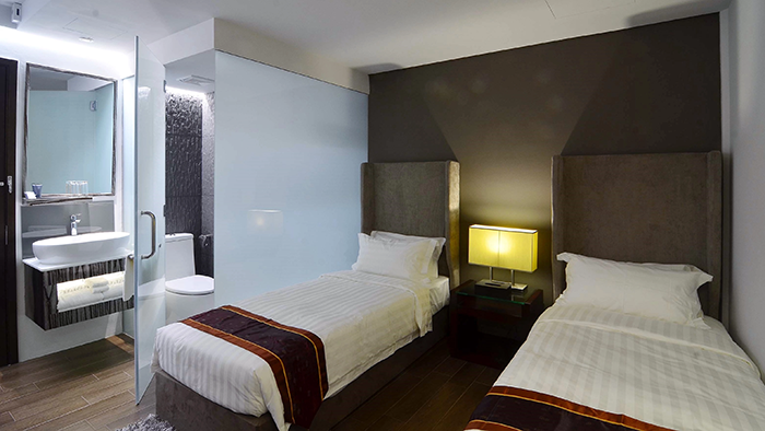 A guest room at the Bliss Hotel Singapore featuring two twin beds.
