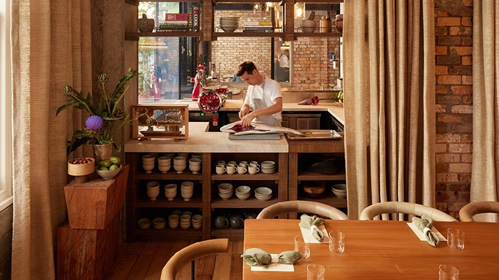 A restaurant at The Hotel Britomart. A staff member is seen filleting a large fish.