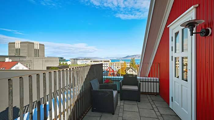 A balcony at the Canopy by Hilton Reykjavik City Centre. A picturesque view of Reykjavik and the surrounding landscape is on display.