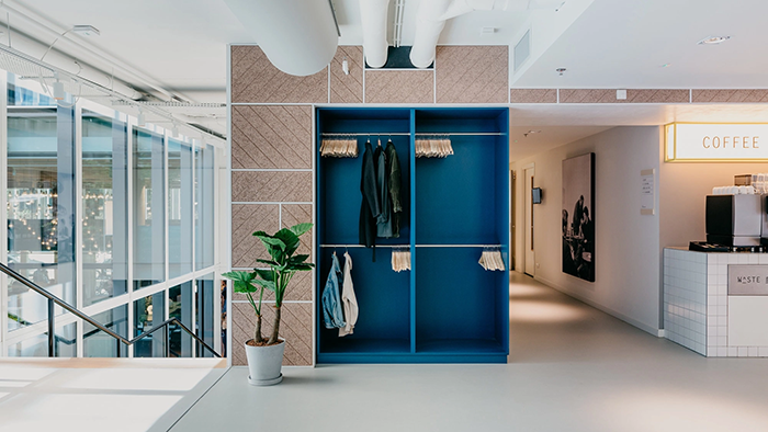 A common area inside the Hotel Casa Amsterdam. Five coats hang in a small blue closet at the center of the photo.