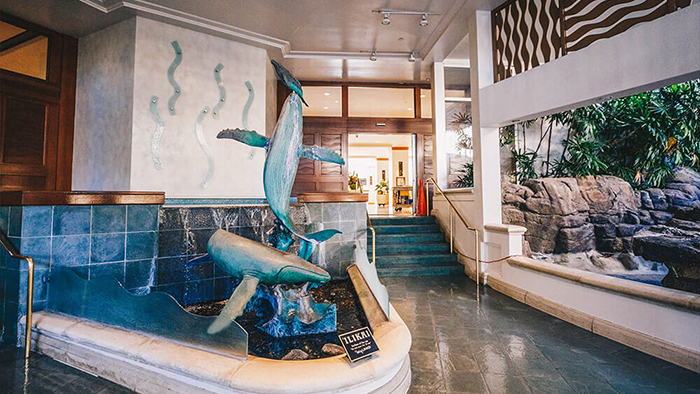 An area inside of the The Castle Ilikai Tower. A sculpture of two humpback whales waits to greet guests as they pass by.