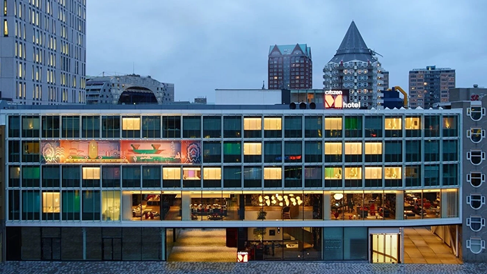 An exterior view of the citizenM Rotterdam hotel nestled among Rotterdam's iconic architectural works.
