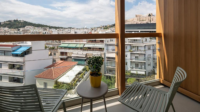 A guest room's balcony at the Coco-Mat Athens BC hotel with a view of the Acropolis.