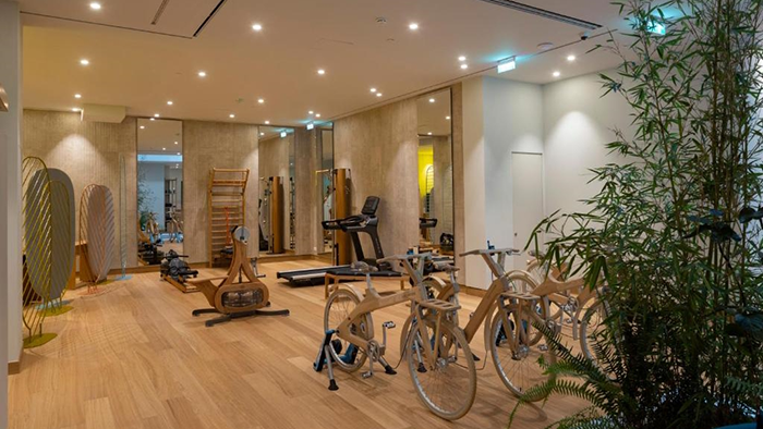 The fitness center inside the Coco-Mat Athens BC hotel featuring a variety of exercise equipment including three stationary bikes.