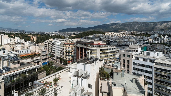A view of the Athens cityscape from the Coco-Mat Athens BC hotel with a mountainous landscape in the background.