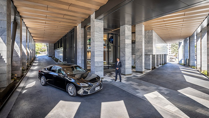 A doorman waits to open the door of an approaching car at the Cordis, Auckland hotel.