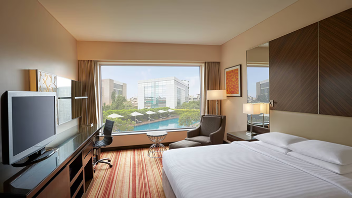 A guest room at the Courtyard by Marriott Mumbai International Airport Hotel. The pool is visible through the window.