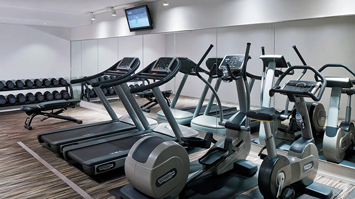 The fitness center at Courtyard Tokyo Station. A set of free weights are seen on the left side of the image.