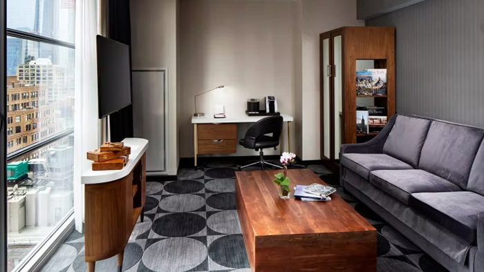 A guest suite at the Crowne Plaza HY36 Midtown Manhattan hotel. Interestingly, the television and entertainment console are positioned in front of a window.