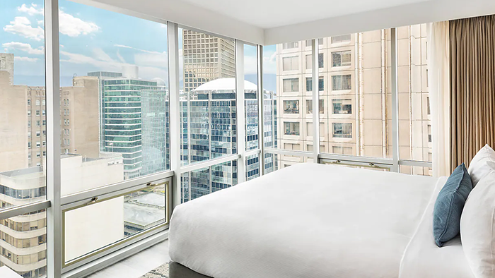 A guest room inside the Delta Hotels by Marriott Vancouver Downtown Suites. This corner room has floor-to-ceiling windows and offers incredible views of downtown Vancouver.