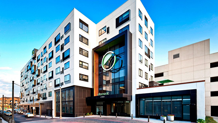 The exterior of the Element Harrison Newark hotel. The building has a bit of an abstract design, with some rooms' windows protruding from the building in an aesthetically pleasing manner.