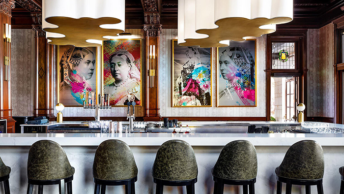 A bar inside the Fairmont Empress hotel. Four artistic depictions of Queen Victoria I are seen hanging from a wall.