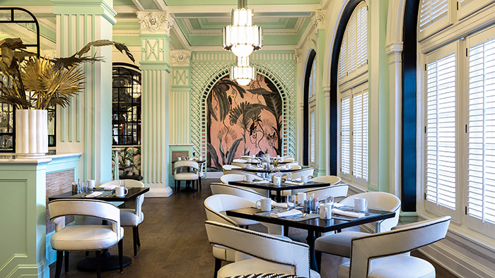 A restaurant inside the Grand Galvez hotel. The walls are painted in a pastel green-ish blue color.