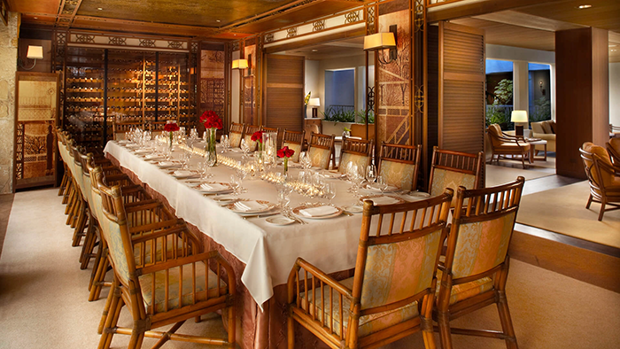 A dining room at the Halekulani Hotel. A collection of wines is visible towards the back of the room.
