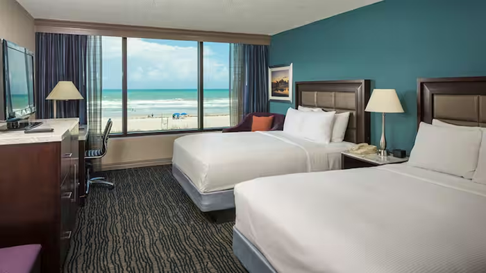 A guest room at the Hilton Cocoa Beach Oceanfront hotel. The window of this room faces the ocean, offering guests a great view of the beach.