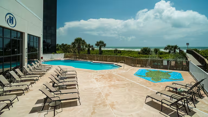 The pool area at the Hilton Cocoa Beach Oceanfront hotel. To the right of the main pool is a shallow splash zone for children.