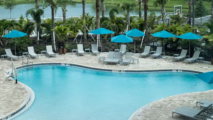The pool at the Home2 Suites by Hilton Cape Canaveral Cruise Port hotel. A basketball hoop is visible in the background.