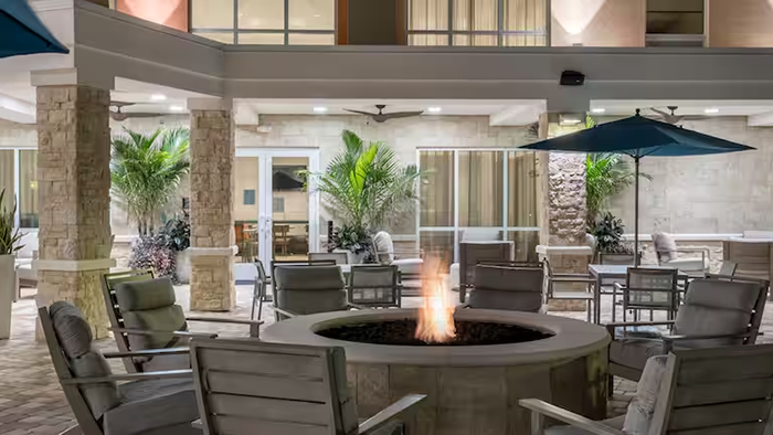A common area with seating and a fire pit at the Home2 Suites by Hilton Cape Canaveral Cruise Port hotel.