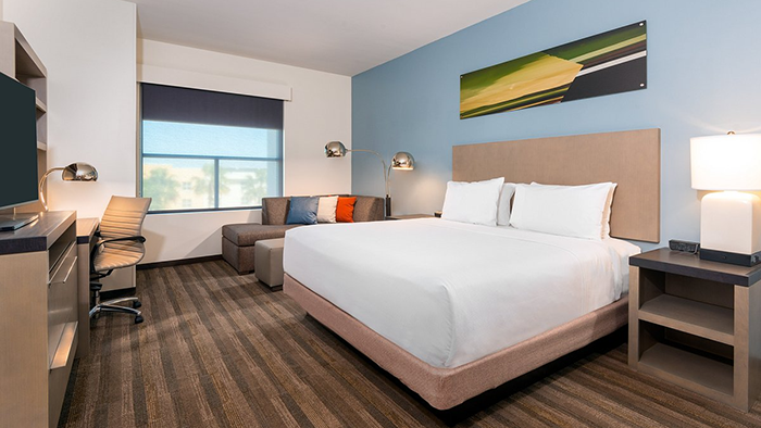 A guest room inside the Hyatt House Tampa Airport / Westshore hotel. The room as a whole looks nice enough, but a horribly ugly piece of art hangs above the bed.