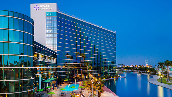 The exterior of the Hyatt Regency Long Beach hotel. The facade of the building is mostly glass, and a large 
