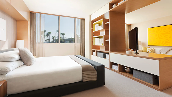A guest bedroom at the Hyatt Regency Long Beach hotel. In classic Californian fashion, several tall palm trees can be seen through the window.