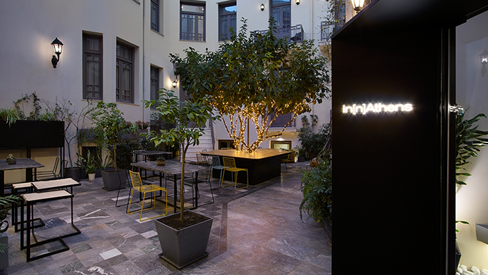 The courtyard at in[n]Athens hotel. Guest room balconies overlook the serene space.