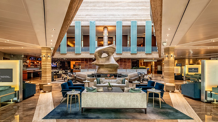 The main lobby at InterContinental Miami, an IHG Hotel. There's a huge abstract sculpture in the center of the large room.
