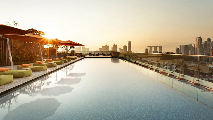 The rooftop pool at JEN Singapore Orchardgateway Hotel by Shangri-La. The iconic Singapore skyline is visible in the background.