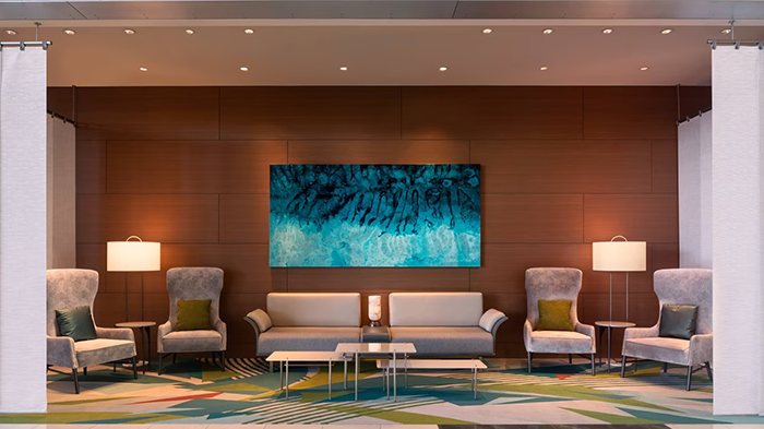 A common area inside the JW Marriott Los Angeles L.A. LIVE hotel. A piece of abstract art hangs from the wall above a couple seats.