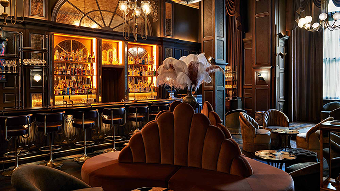 One of the bars at The Kimpton Fitzroy London Hotel. In the center of the image, several feathers are arranged in flowery fashion.