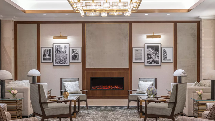 A common area with seating and a fireplace inside The Langham, Boston.