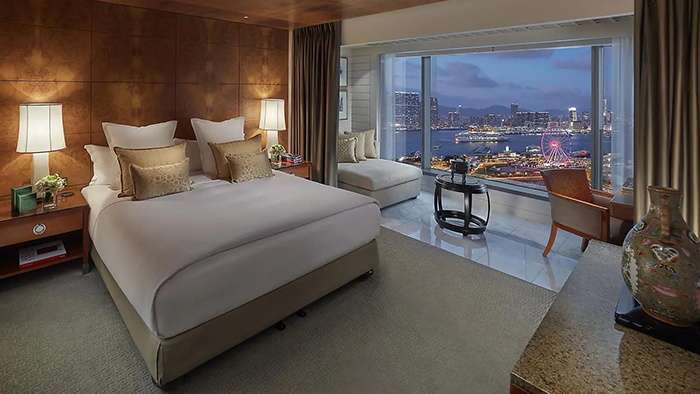 One of the Mandarin Oriental, Hong Kong's guest suites. There's a beautiful view of Hong Kong at night visible through a large window.