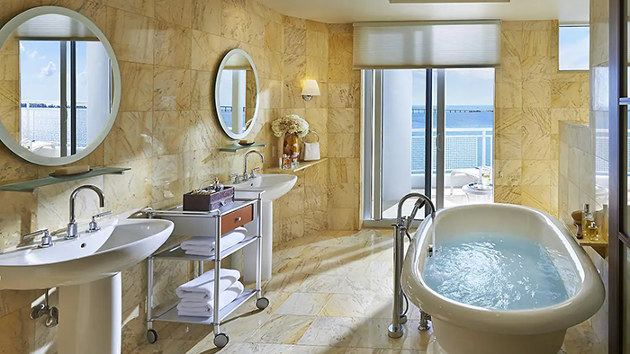 An en-suite bathroom inside the Mandarin Oriental Hotel in Miami. It features two sinks and a freestanding bathtub.
