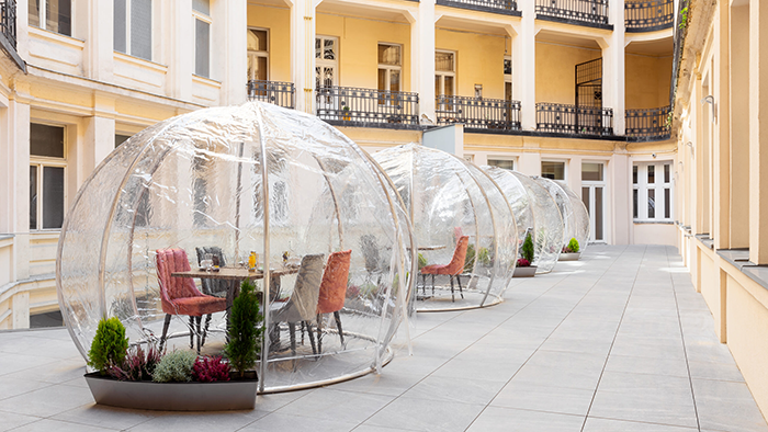 The Mera Hotel's courtyard. Four dining tables are encased in climate controlled plastic bubbles.