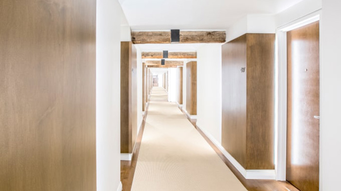 A hallway lined with guest rooms at Le Monastre des Augustines in Qubec City.