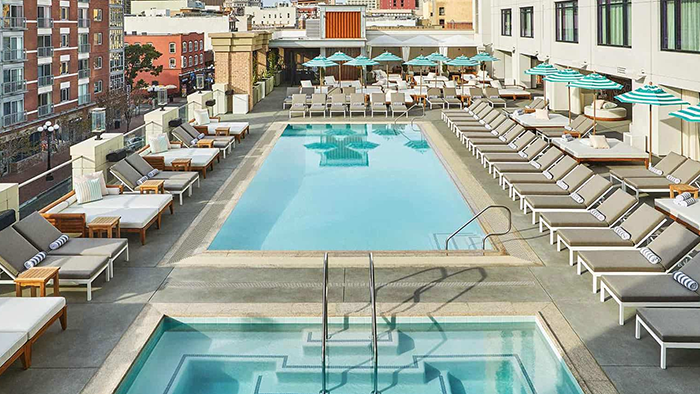 Pendry San Diego's rooftop pool and hot tub. A lovely view of the city is visible in the background.