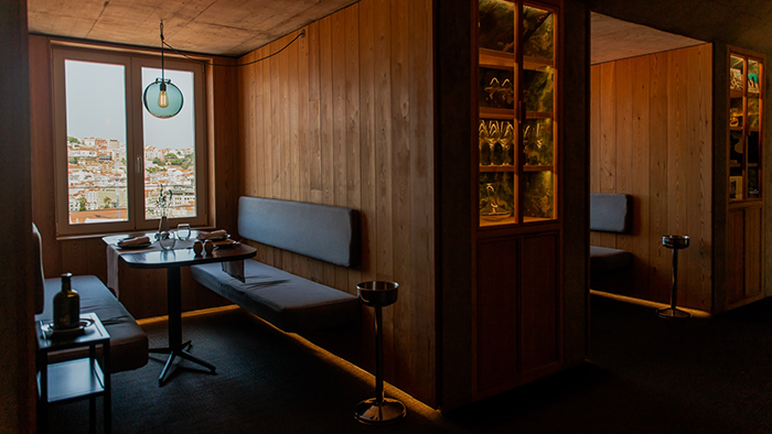 Booth seating inside the Lisboa Pessoa Hotel. The wood walls and dim lighting give the space a cozy atmosphere.