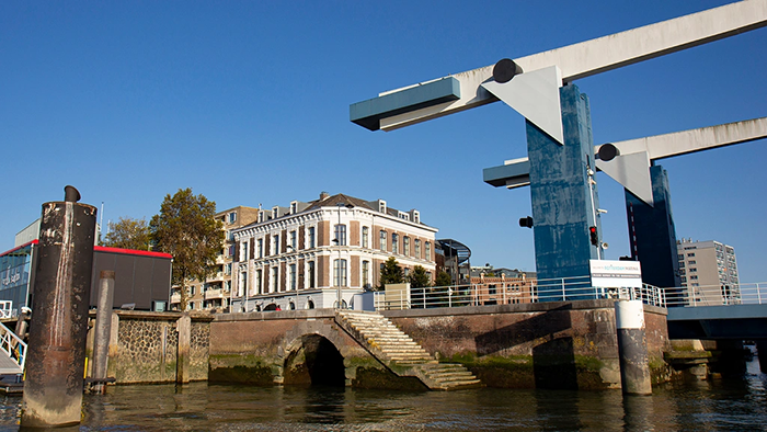 The outside of the Suite Hotel Pincoffs Rotterdam. An interestingly designed bridge is visible on the right side of the image.
