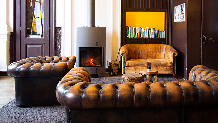 A common area inside the Suite Hotel Pincoffs Rotterdam. There are three brown leather couches, and they all look incredibly comfortable.