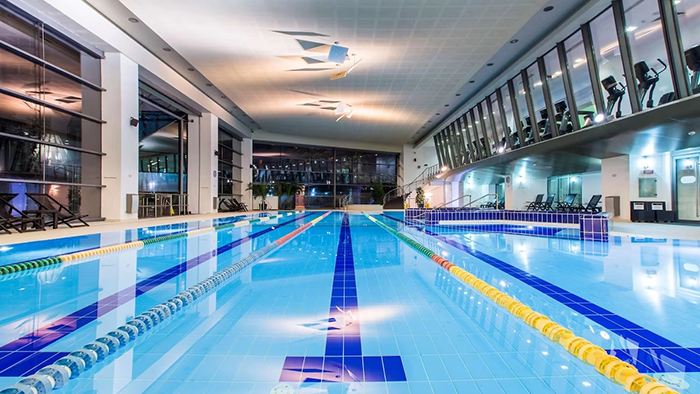 The indoor pool at the Radisson Blu Hotel in Bucharest. You can see the fitness center through the glass windows at the top right of the image.