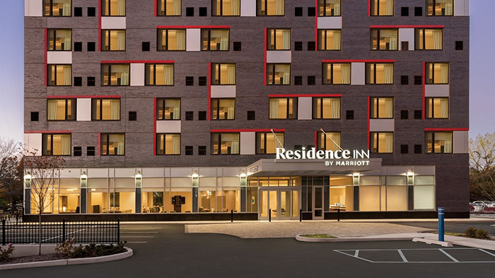The front of the Residence Inn by Marriott New York JFK Airport hotel. The building's facade is painted in mildly abstract fashion.