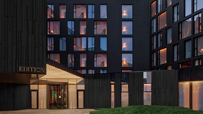 An exterior image of The Reykjavik EDITION Hotel in Reykjavk, Iceland. The building is painted a striking black color.