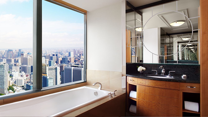 A guest bathroom at The Ritz-Carlton, Tokyo. A large window allows guests to enjoy an incredible view from the comfort of their bathtub.